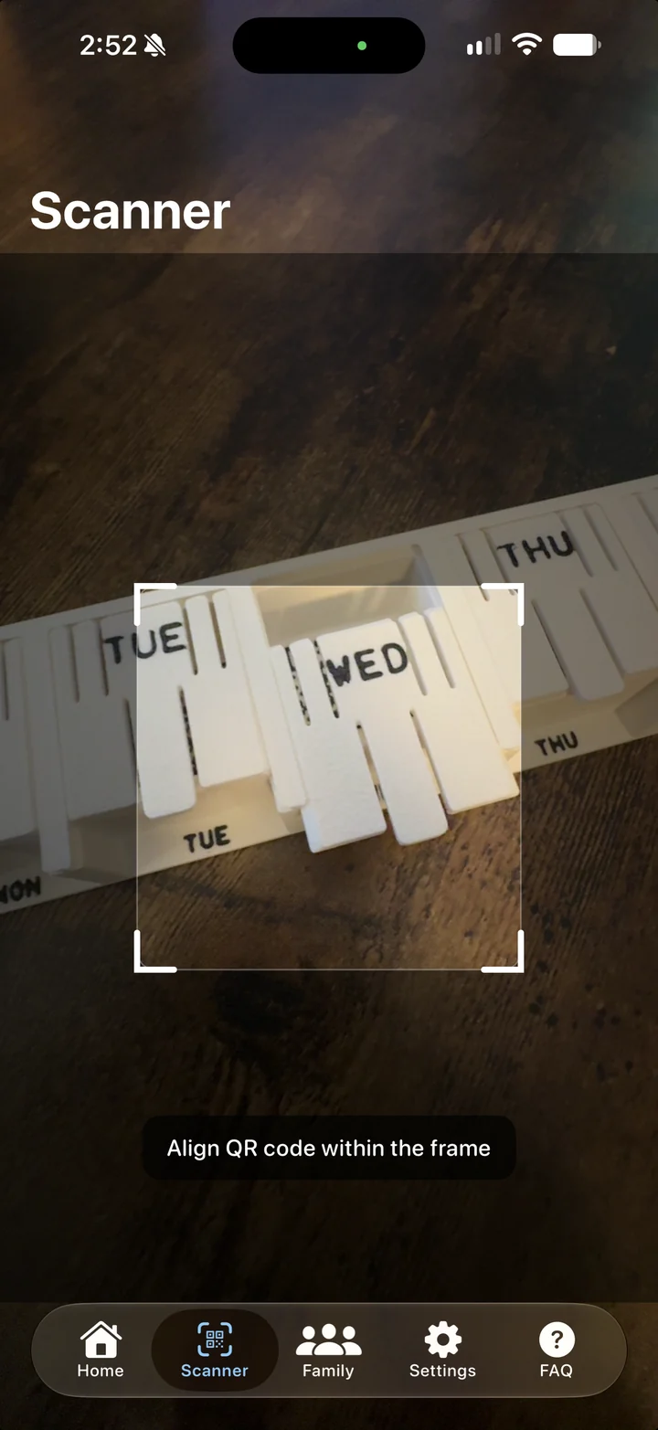 DYTYM Scanner on an iPhone, the camera aimed at a white printed organizer's Tuesday, Wednesday and Thursday lids inside the scanning frame, with the prompt Align QR code within the frame.
